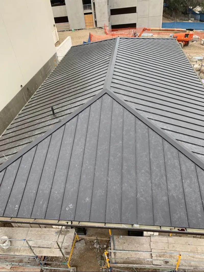 Commercial metal roof construction with crane equipment in Aptos
